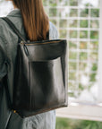 Leather backpack Andes L worn on the back, black color, convertible straps visible.