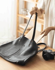 Leather Tote Bag
Full grain leather, unlined hand bag. It features two open exterior pockets and one internal zippered pocket. It comes with fixed leather handles. It’s held shut by a sturdy snap closure.