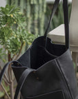Leather Tote Bag
Full grain leather, unlined hand bag. It features two open exterior pockets and one internal zippered pocket. It comes with fixed leather handles. It’s held shut by a sturdy snap closure.