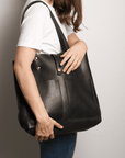 Leather Tote Bag - Full grain leather, unlined hand bag. It features two open exterior pockets and one internal zippered pocket. It comes with fixed leather handles. It’s held shut by a sturdy snap closure.