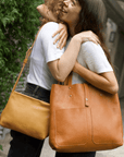 Leather Tote Bag
Full grain leather, unlined hand bag. It features two open exterior pockets and one internal zippered pocket. It comes with fixed leather handles. It’s held shut by a sturdy snap closure.