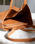 Leather Tote Bag unlined hand bag. It features two open exterior pockets and one internal zippered pocket.