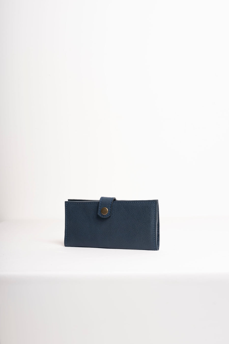 Natural-grained unlined wallet. It features a front snap closure, 8 card slots, 2 bill compartments plus a zippered interior pocket.