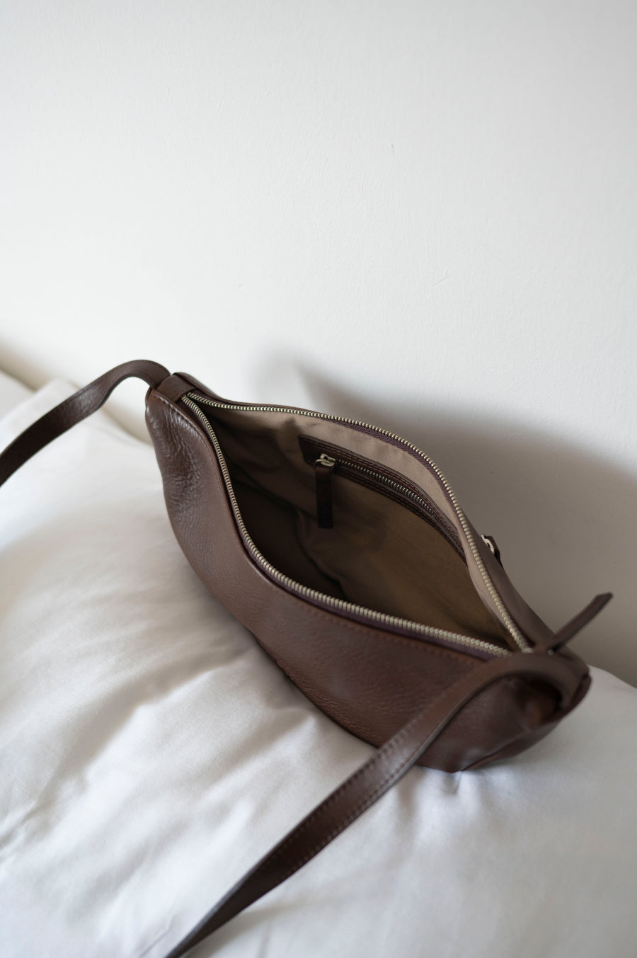 This full-grain leather Sling bag is designed for comfort and convenience, making it a great travel accessory or festival bag. With a durable metal zipper closure, cotton lining, and an adjustable strap, this versatile leather belt bag can be worn comfortably as a crossbody bag or hip bag. The back features an exterior zippered pocket for added security.