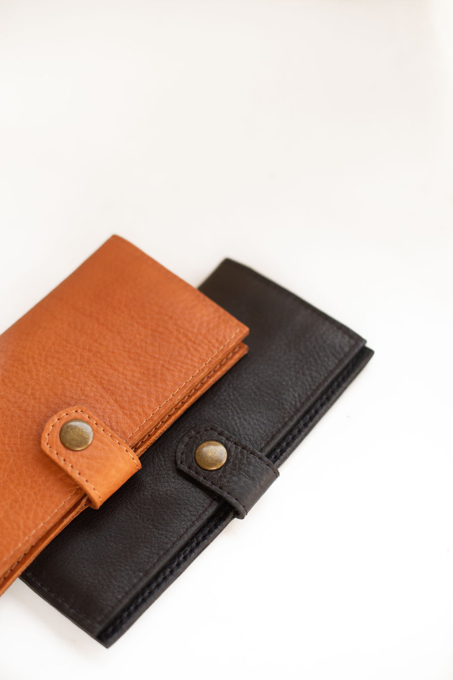Natural-grained unlined wallet. It features a front snap closure, 8 card slots, 2 bill compartments plus a zippered interior pocket.