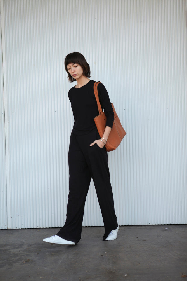 Leather Tote Bag unlined hand bag. It features two open exterior pockets and one internal zippered pocket. 